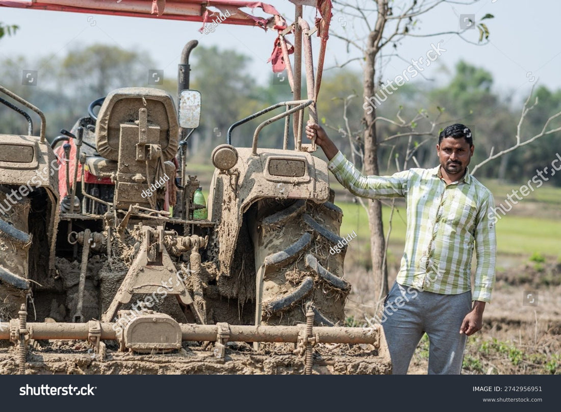 Indian farmer standing next to agricultural machinery