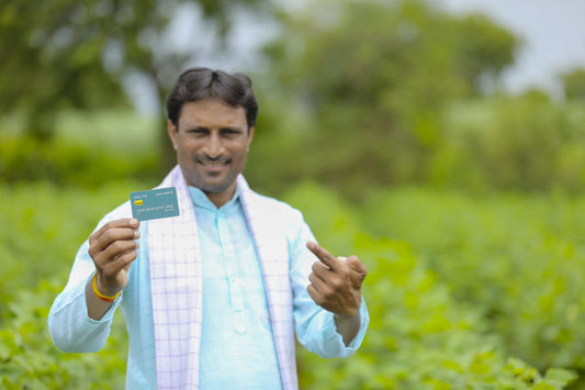 indian farmer holding kisan credit card document field