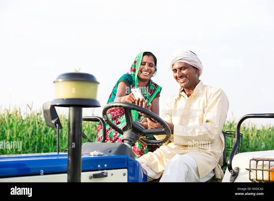 Indian farmer laughing on a tractor field