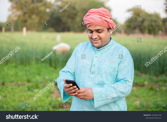 happy Indian farmer using smartphone irrigation app field
