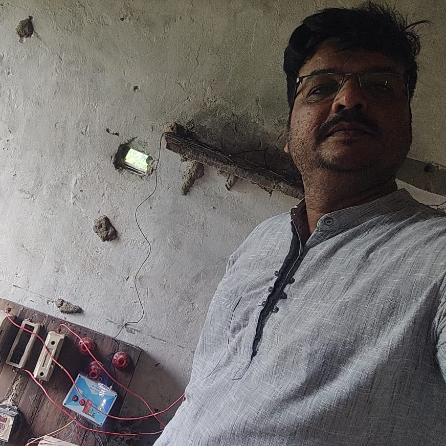 Man standing in a room with a concrete wall and electrical components.